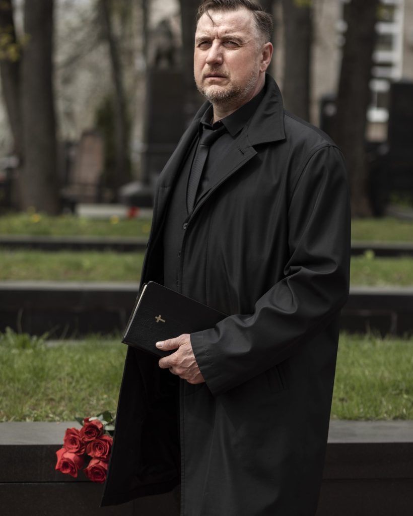 homem-com-flores-e-biblia-no-cemiterio